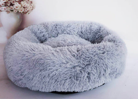 "Ultra-soft, fluffy pet bed designed for deep sleep and relaxation. Features a plush, round donut shape with cozy faux fur for warmth and comfort. Ideal for cats and small dogs to curl up and enjoy a restful sleep."