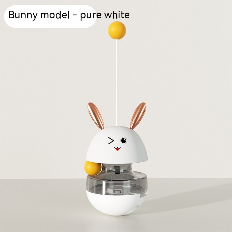 "Bunny-shaped interactive pet food tumbler with a wobbling base, treat dispenser, and playful stick with a yellow ball. Engages pets with fun and stimulating play."